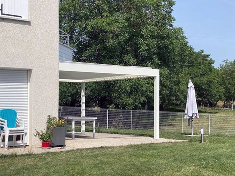 Terrasse extérieure résidentielle avec pergola bioclimatique à lames orientables blanches