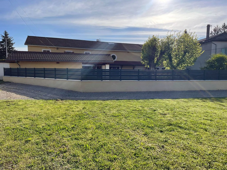 Scène extérieure résidentielle avec maison contemporaine à toiture tuiles noires et façade beige