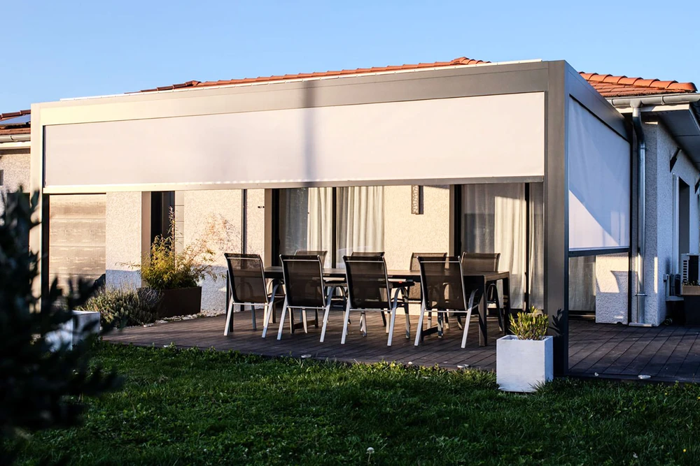 Scène extérieure de chantier résidentiel avec ouvriers installant une pergola bioclimatique sur terrasse